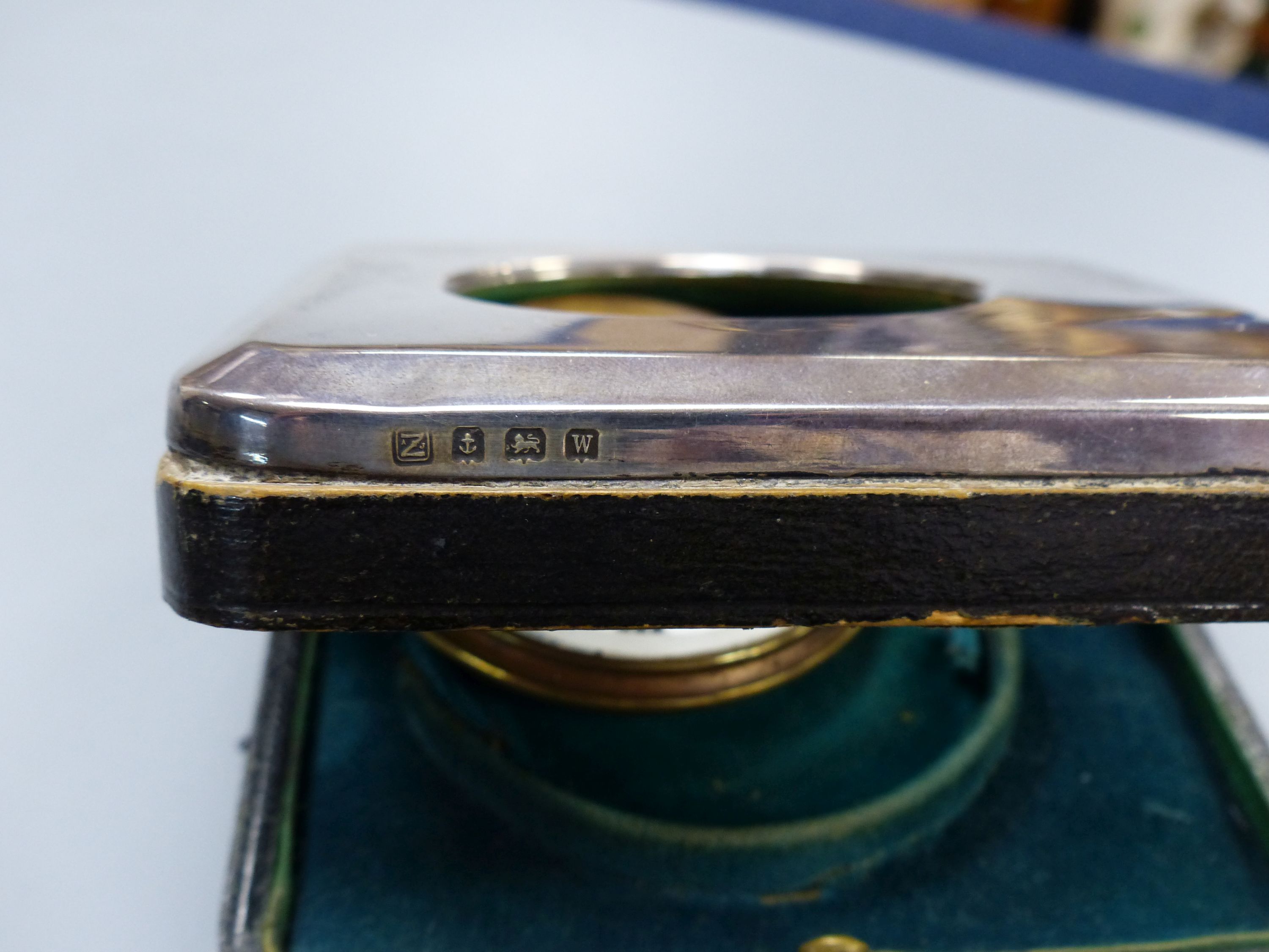 A George V silver mounted travelling watch case, with an incomplete nickel cased pocket watch, 11.2cm.